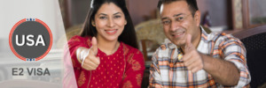 Happy couple giving thumbs up after receiving E2 visa approval.